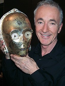 Anthony Daniels montrant le masque de C-3PO.