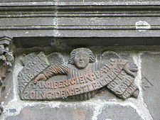 An angel holds a banner inscribed in Breton "AN:MARO:HAN:BARN:HAN:INFERN:IEN:PA:HO:SOING:DEN:E:TLE:CRENA FOL:EO NA:PREDER" which translates as "La Mort, le Jugement, l'Enfer glacé, quand l'homme y songe, il doit trembler" or "Death, judgment, freezing hell. Think on that and fear it".[4]