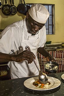 Photographie d’un homme avec une toque de chef.