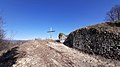 Foto di parte delle mura della fortezza medievale e della croce presenti sul Monte Bastia.