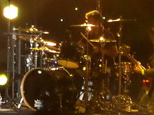 Woodgate sitting at a drum kit