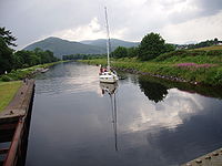 A sailing boat on the Caledonian Canal approaches from the Loch Linnhe side of the Mallaig Extension Railway swing bridge.