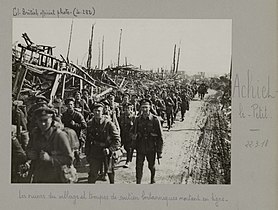 Les troupes britanniques traversant le village en ruines en mars 1918.