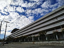 Foto da Central Acadêmica Paulo Freire em plano lateral, mostrando o prédio branco de três andares.