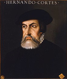 Vieja pintura de un hombre joven con barba, mirando ligeramente hacia la derecha. Lleva una chaqueta oscura con un cuello alto coronado por una gorguera blanca, con botones ornamentales en la parte delantera. La pintura es oscura y está colocada en un óvalo con las letras "Hernán Cortés" en un rectángulo debajo.