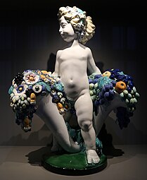 Secessionist putto with two cornucopias with floral cascades, very similar to the ones found in a lot of Art Deco of the 1910s and 1920s, by Michael Powolny, designed in c. 1907, produced in 1912, ceramic, Kunstgewerbemuseum Berlin[234]