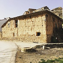 Primer plano de una casa antigua y en no muy buen estado. La fachada es color arena hecha con adoble.