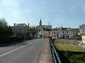 Photographie en couleurs de maisons étagées sur un coteau surmonté par une église.