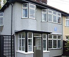 A grey two-storey building, with numerous windows visible on both levels