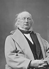 Portrait dessiné en noir et blanc, de profil d'un homme blanc, cheveux blancs et front dégarni avec de petites lunettes rondes, assis, bras croisé