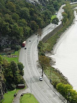 Aerial view of a road next to a river gorge, with traffic along it