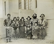 Photo d'un groupe de sept personnes alignées et portant des costumes traditionnels aïnous.