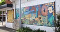 One of two painted historical murals in St Marys. The leftmost section recites a poem titled 'South Creek' which tells of the rough journey that the pioneers made - from the eastern shoreline of Sydney, inland towards the Blue Mountains - and legacy of their settlements that they passed to their descendants. The right two-thirds of the mural depict the heritage-listed Mimosa house, the War Memorial in Victoria Park, one of Bennett works' wagons, and several persons of historical note