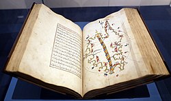 Large book open with Arabic text on one page and a multicolor illustrated map opposite