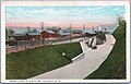 A color postcard of a railway station next to a road