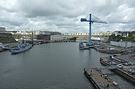 La Penfeld vue vers l’amont depuis le pont de Recouvrance. De gauche à droite : l’entrée des bassins de Pontaniou, barrée par le batardeau mis en place à l’occasion des travaux de modernisation de 2006 ; les ateliers du plateau des Capucins ; la direction de DCNS ; le pont Tréhouart ; la Grande Grue ; l’entrée du bassin Tourville