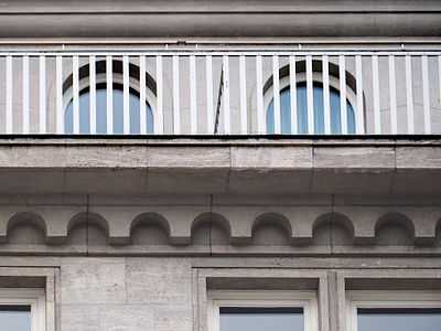 Detailfoto mit Reling, Rundbogenfries und den Faschen der Fenster.