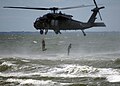 SEALs saltando al mar dende un helicópteru UH-60 Black Hawk