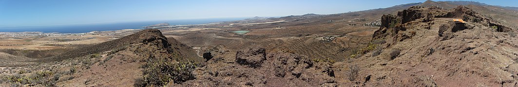 View towards the south-east from the Four Doors site. On the coast, almost in line with the forefront left peak: the Punta de Gando and Gran Canaria airport just in front of it.