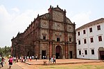 Unha igrexa de ladrillo vermello e un edificio adxacente en branco