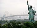 En etterlikning av Frihetsgudinnen (New York) med brua Rainbow Bridge i bakgrunnen.