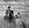 Fotografía de 1940, en el que aparece un huaso de Chile junto a su pareja que sostiene una gavilla, en medio de un trigal. El huaso es un personaje típico del Chile Central, que labora en ámbitos ganaderos y agrícolas. Por Toni Frissell, retocada por en:Arad.