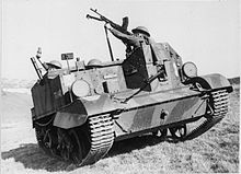 An open-topped military vehicle containing soldiers, who point a mortar and a machine gun upwards.