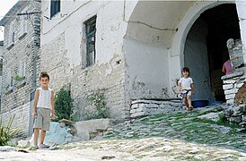 Mai: Gjirokastra: Kinder vor einem typischen alten Wohnhaus aus Stein