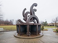 Sculpture of connected semicircles atop a round base