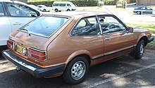 Rear three-quarter view of a three-door car with a two-box body style whose luggage compartment is integrated into the passenger cockpit.