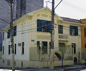 Photographie d'une maison jaune dans le coin de la rue