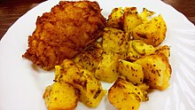 A Pozharsky cutlet with cubed potatoes on a plate