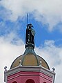 Statue of Cuauhtémoc standing above the tower dome of Casa Bonita