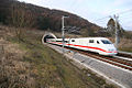 White electric train with red cheatline emerging from tunnel in the countryside (পরিবহন থেকে)