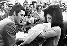 Photo of Elvis Presley kissing his new bride Priscilla