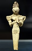 Lizard-headed nude woman nursing a child, Ur, Ubaid 4 period, 4500-4000 BCE, Iraq Museum. "The elongated head, similar to the figures found at Eridu, could represent an elaborate headdress or possibly cranial binding".[37]