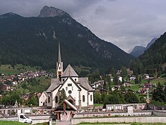 Pfarrkirche San Vigilio (16. Jh.) mit dem San Pellegrino-Tal im Hintergrund