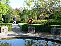 Ornamental garden with stone blocks with incised lettering around the edge of a pond