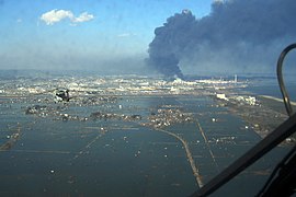 Luftbildaufnahme der überschwemmten Region über dem Hafen von Sendai (Foto: 12. März 2011)