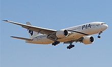 Aircraft landing approach. Front quarter view of twin-engine jet in flight with flaps and landing gear extended.