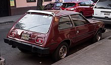 Une voiture rouge, vue de trois-quarts arrière.