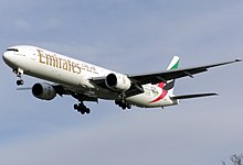 Aircraft landing approach. Front quarter view of twin-engine jet in flight with flaps and landing gear extended.