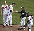 Image 25A pitcher handing off the ball after being taken out of the game during a mound meeting. (from Baseball)