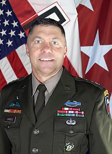 Head and shoulders photo of Major General Mark H. Landes, dress uniform, head and shoulders, in front of United States and First Army flags