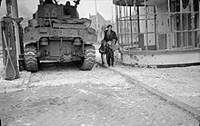 A Dutch civilian lifts his two children away from danger near a Sherman tank during fighting in 's-Hertogenbosch