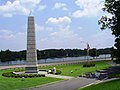 Séadchomhartha The Spirit of American Citizenship ar Shráid Rainbow (US 411), in aice leis an droichead Broad Street Bridge. Tá an abhainn Coosa agus East Gadsden, Alabama infheicthe sa chúlra.