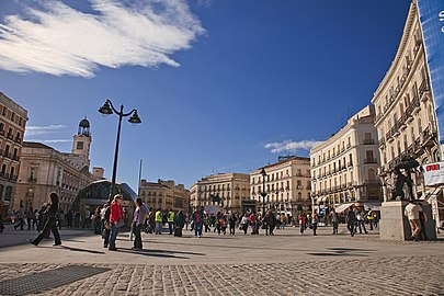 Puerta del Sol, Madrid, donde se halla el kilómetro cero de las carreteras españolas. Acogió hechos históricos como el levantamiento del dos de mayo de 1808 (pintado por Goya) y la proclamación de la Segunda República Española el 14 de abril de 1931. Las campanadas de año nuevo de su reloj son vividas en toda España con el ritual de las doce uvas.