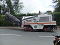 Folded conveyor on a tracked grinder