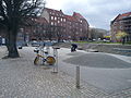 The square of Steen Billes Torv with city bikes, playgrounds and a green area.