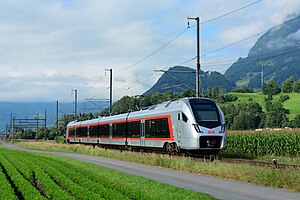 Silver and red train next to island platform